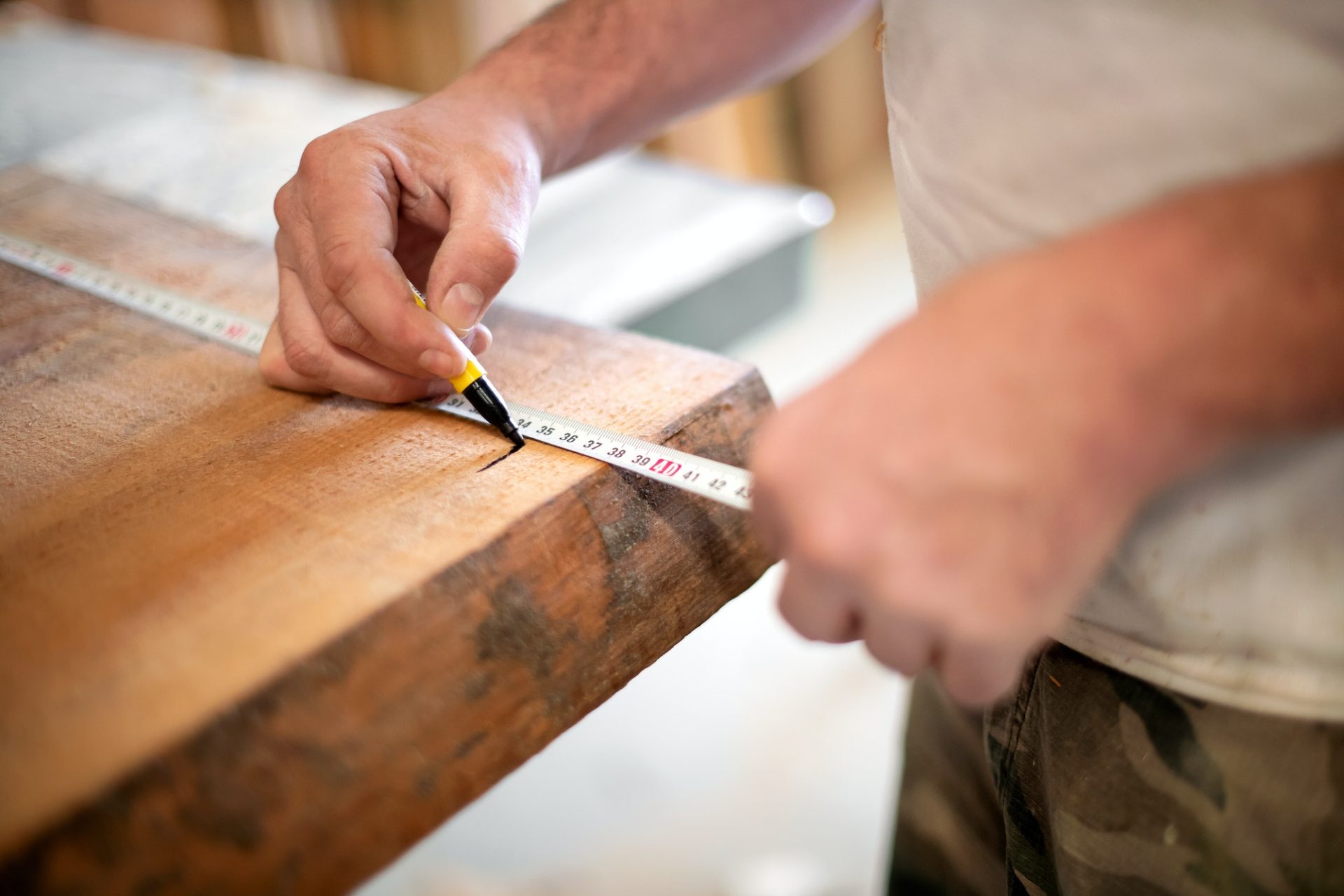 Woodworker taking measurement with a tape